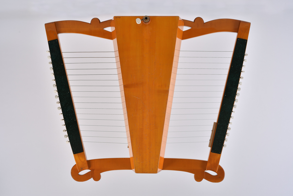 Strengeinstrument som knipses. Består av en trapesformet ramme av lønn med klangkorpus. likeledes trapesformet i senter av rammen. Klangbunn av gran med lydhull i form av små hull plassert i fire ovaler. Anhengslist langs midten av klangbunnen.
2 X 17 strenger, 17 til hver side fra anhengslist mot rammens sider der stemmeskruene befinner seg.