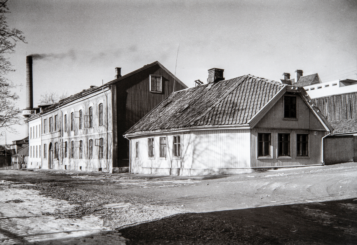 Hamar, Vestbyen, Skappels gate 15 og 17 i krysset med Heidmanns gate 12, pipa til Melkefabrikken i bakgrunnen,