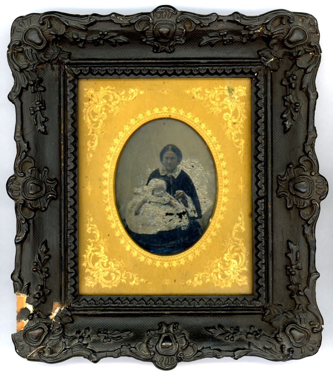 Beda Hallbergs arkiv. Ambrotypi med tätslutande guldfärgat etui och svart ornamenterad ram (skadad). Ramens yttermått ca 175 x 200 mm, innermått ca 105 x 120 mm, den ovala öppningen ca 75 x 60 mm. 

Beda Hallbergs mor Josefina Andersson (född Möller 1835) med någon av döttrarna Alida f. 1859, Gerda f. 1862 eller Beda f. 1869. Familjens två första barn föddes i Carl Johans församling och de flyttade till Onsala 1862 där de två andra syskonen föddes. Var fotografiet togs är här okänt.