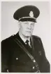 Polisman Gunnar Johansson, Älghult, i full uniform, ca 1955-60.
Bröstbild, halvprofil. Ateljéfoto.