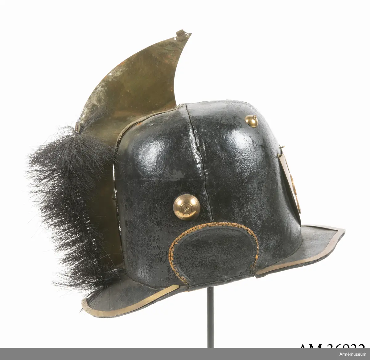 Kask med vapenplåt för manskap vid Västgöta (linje-)dragonregemente, troligen 1805-1807. Inrättad för plym som fattas. Vapenplåt med Gustaf IV Adolfs namnchiffer.