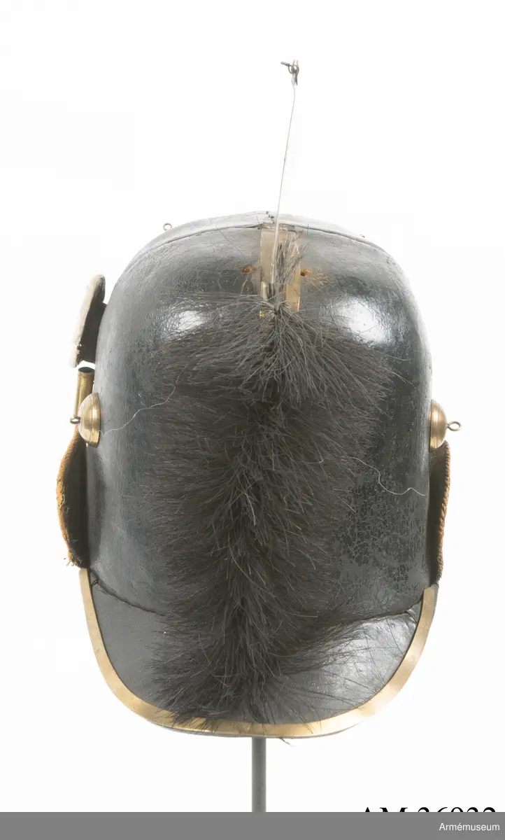 Kask med vapenplåt för manskap vid Västgöta (linje-)dragonregemente, troligen 1805-1807. Inrättad för plym som fattas. Vapenplåt med Gustaf IV Adolfs namnchiffer.