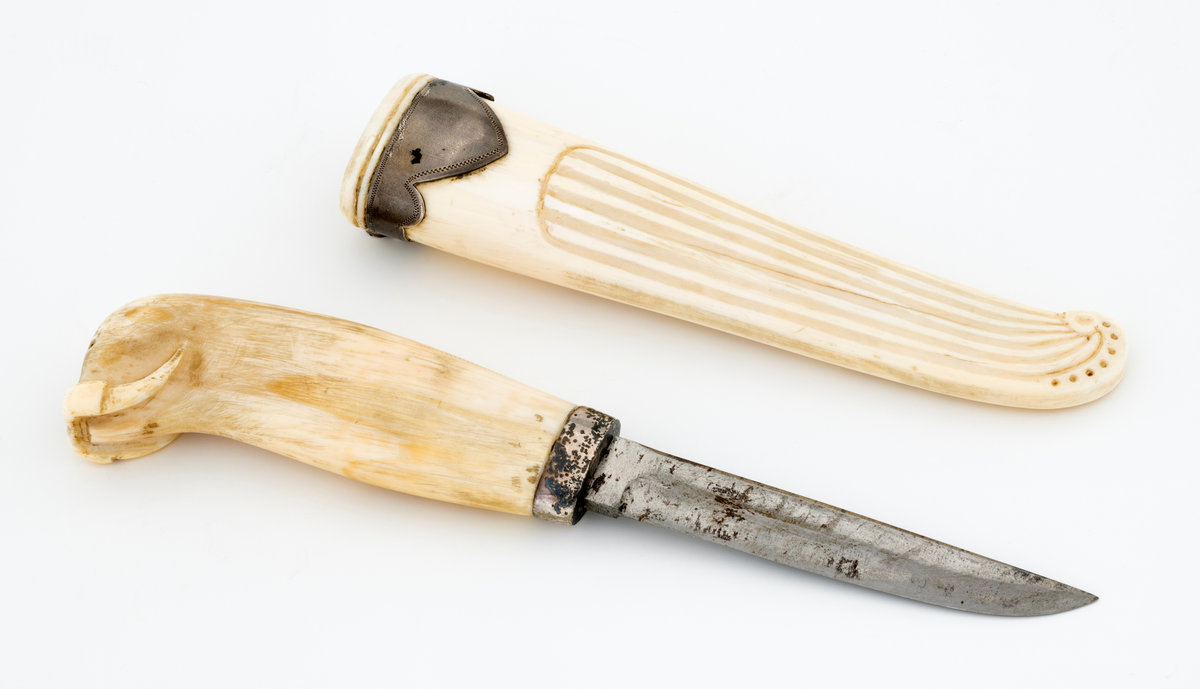 Tollekniv som har tilhørt offiseren og polfareren Hjalmar Johansen (1867-1913), som var kjent fra Fridtjof Nansens Fram-ekspedisjon (1893–1896) og Roald Amundsens Sørpolekspedisjon (1910–1912). Kniven har blad som antas å være av jern og stål, mens skaftet og slira skal være utført i hvaltann, for sliras del suplert med en skaftholk av sølv. Skaftet og slira er åpenbart håndlagde, men vi kjenner foreløpig ikke knivmakerens indentitet.

Kniven er 18,9 centimeter lang. Bladet utgjør 9,2 centimeter av dette lengdemålet. Det er 1,5 centimeter bredt bakerst ved brystningen. Her er tjukkelsen 3,2 millimeter, men bladet tynnes gradvis mot spissen, hvor det er 2,1 millimeter tjukt. Den bakre delen av bladryggen er rettlinjet, men de fire fremste centimeterne skrår svakt ned mot bladspissen. Kantene på bladryggen er noe avfasete. Slipefasene på eggsida er opptil 8 millimeter brede. Bladet har ingen stempler eller andre signaturer som tydeliggjør produsentens identitet, men mye tyder vel på at dette er et «fabrikkblad» - altså en masseprodusert komponent.

Tangen i den bakre enden av skaftet er tappet inn i et 9,7 centimeter langt skaft, lagd av gråkvit hvaltann. Den fremre skaftenden er forsterket med en 7,3 millimeter bred skaftholk med glatt overflate. Skaftet er konvekst i formen, og det har, som på knivskaft flest, et ovalt tverrsnitt. Den bakre skaftenden er en aning krum - mot buksida. Denne delen av skaftet er formet som hodet på en hvalross (Odobenus rosmarus), en selart med store, buete hjørnetenner. Denne arten er utbredt i grunne kystområder i det arktiske nord, altså i miljøer eieren av denne kniven besøkte på ekspedisjoner han var med på.

Slira er et 14,8 centimeter langt hylster, tilsynelatende lagd i ett stykke av hvaltann. Den er noe asymmetrisk i lengderetningen. Her er det med andre ord lett å se i hvilke reninger bladryggen og egglinja skal ligge når kniven stikkes i slira. Baksida av slira har glatt overflate. På forsida er det skåret et riflemønster som ender i et buet endeparti nederst på slira. Her er det ingen metallbeslag, men sliremunningen i overenden er forsterket ved hjelp av en sølvholk med profilert (flikete) nederkant. På baksida av denne komponenten, som er laget av sølv, er det påloddet ei hengsle for en opphengsstropp, som ikke er intakt.