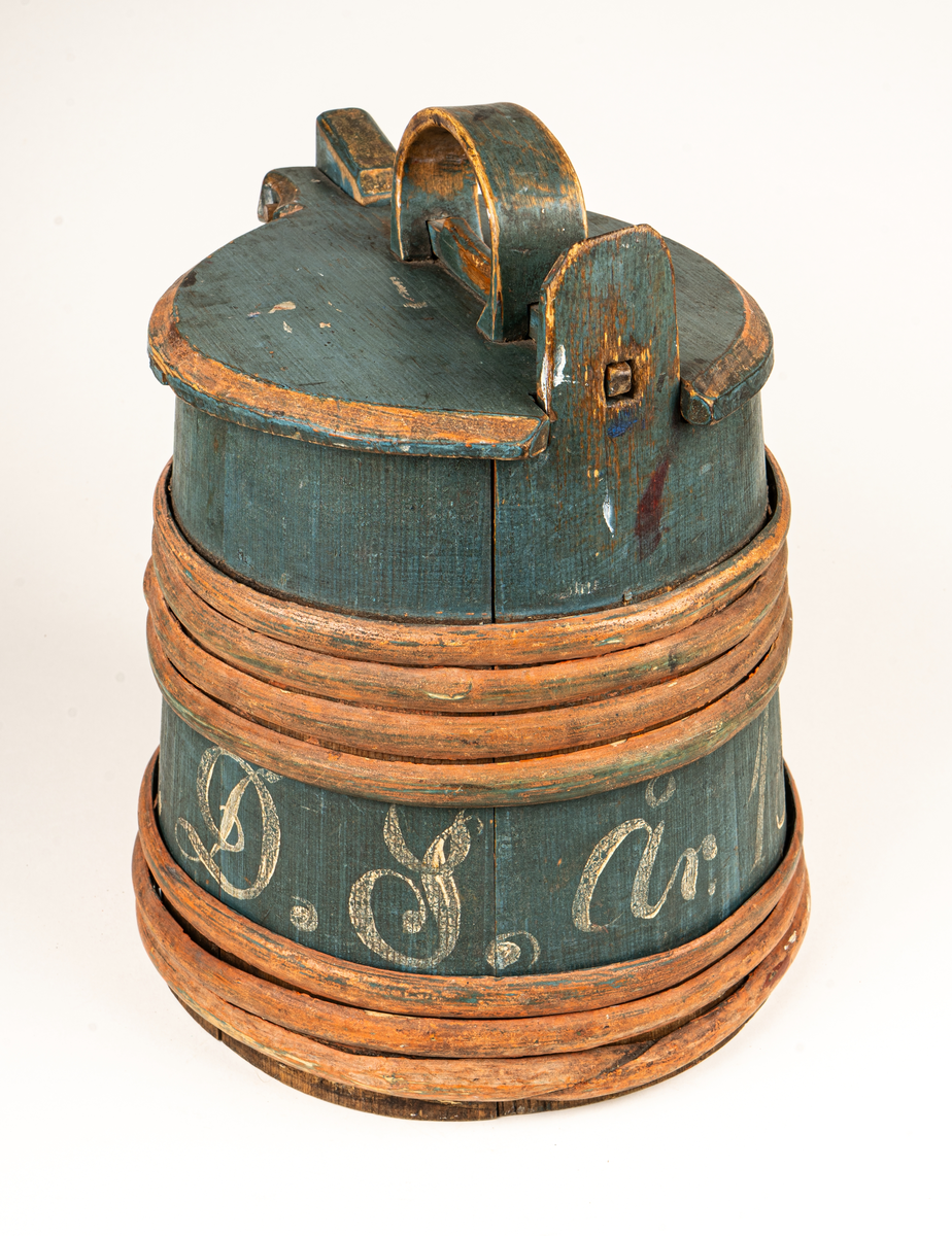 Stånka av trä (furu), laggad, med 7 träband. Målad i grönblått och rött. Märkt DDS år 1853 på sidan med vit färg.