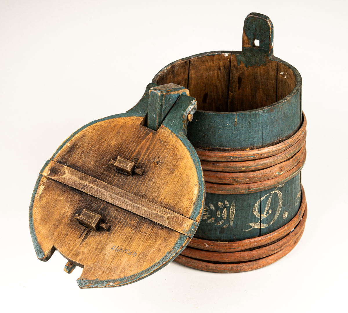 Stånka av trä (furu), laggad, med 7 träband. Målad i grönblått och rött. Märkt DDS år 1853 på sidan med vit färg.