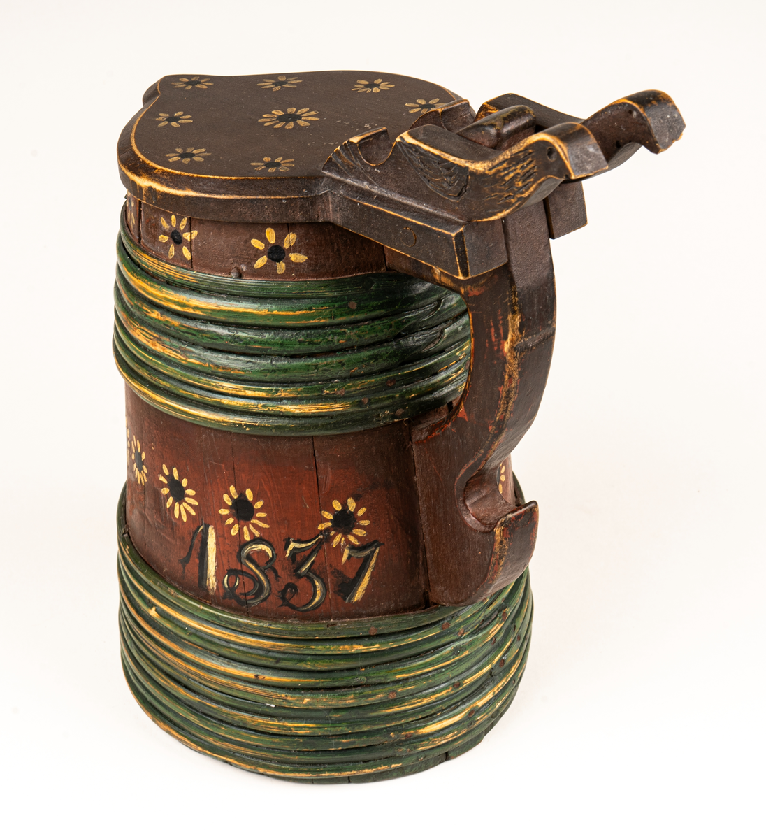 Stånka, laggat, med 17 träband. Locket platt. ovanpå är vid dess fäste två fågelfigurer utslurna. 
Rödmålat med blommor och och blad i svart och gulvitt. Med snip. 
Målad text: B.S.D 1837.