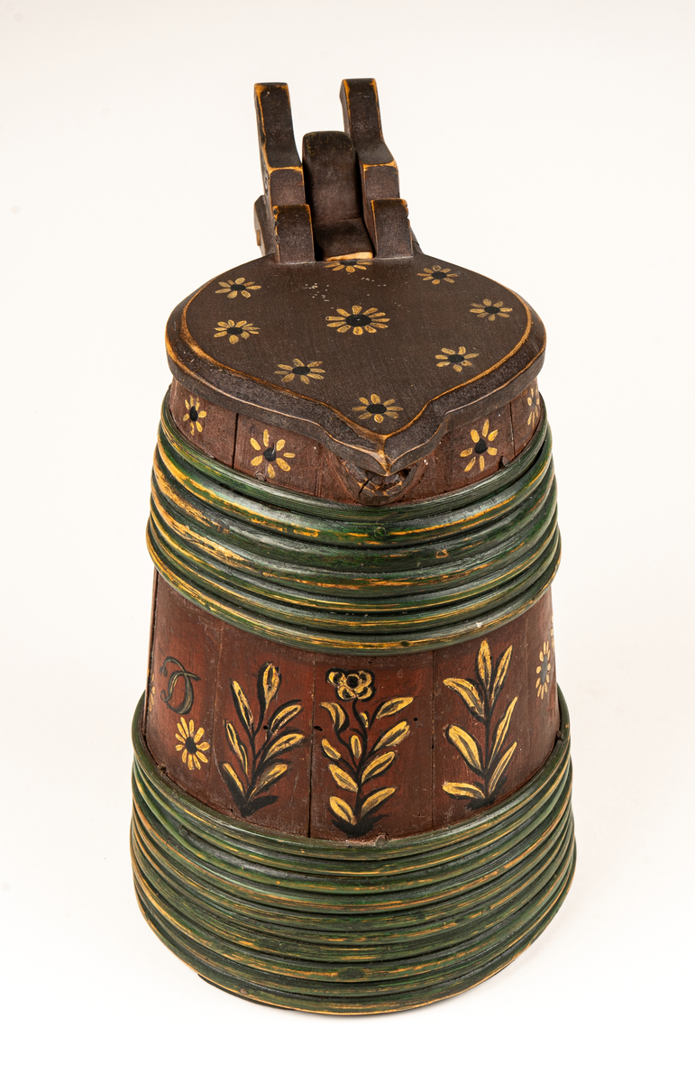 Stånka, laggat, med 17 träband. Locket platt. ovanpå är vid dess fäste två fågelfigurer utslurna. 
Rödmålat med blommor och och blad i svart och gulvitt. Med snip. 
Målad text: B.S.D 1837.