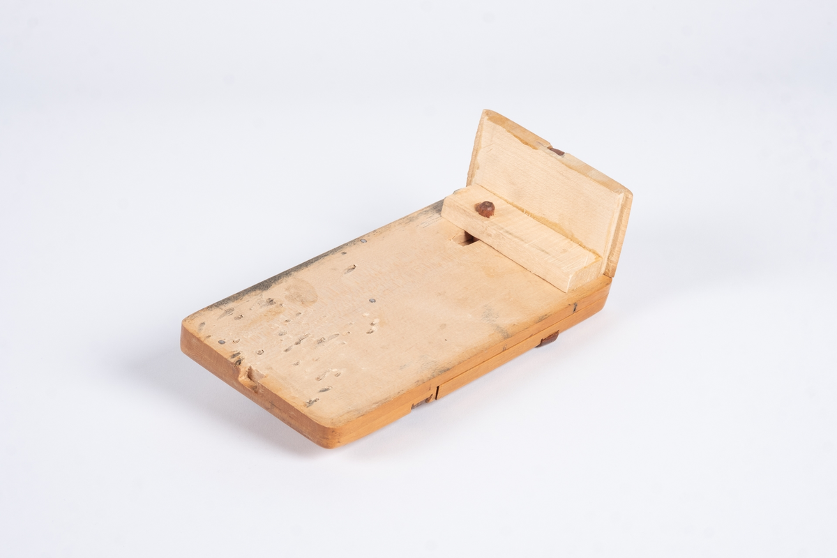 Ey skyvelokk av tre. Lokket er unik med en plate oppå lokket som kan skyves utover. Platen låses/åpnes med en brikke som skyves ut/inn i platen. Det er to runde knotter og to staver med utskjæringer på lokket.