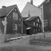 I den tätt bebyggda Barnhemsgatan 6 i Linköping stundade förändring fotoåret 1960. Fastigheten var såld till stadens fastighetsbolag och de gamla trähusen rivningsbeslutade. Inom kort skulle stenhuset i fonden byggas på med en huskropp i tidens snitt.