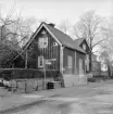 I höjd med Barnhemsgatan 6 i Linköping och ännu minner gatuskyltningen om tiden då stråket var del i lösningen av stadens genomfartstrafik. Fotoåret 1960 var den trafiken nyligen flyttad till lycka för grannskapet.