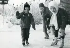 Fotografi på tre barn, två flickor och en pojke, åkandes skridskor, 1969.