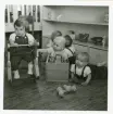 Fotografi på Lars, Mikael och Susanna som leker på golvet vid barnhemmet Lilla Källbäck, 1963.
