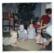Fotografi på Berit, Reine, Anna? och Johan som ligger på golvet och en barnsköterska som är vid sidan om, julen 1963 på Lilla Källbäck.
