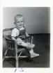 Fotografi på Mikael 1 år, sittande i en liten korgstol.