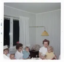 Foto på kvinnor och barn med text vid kortet:  "På Lilla Käl