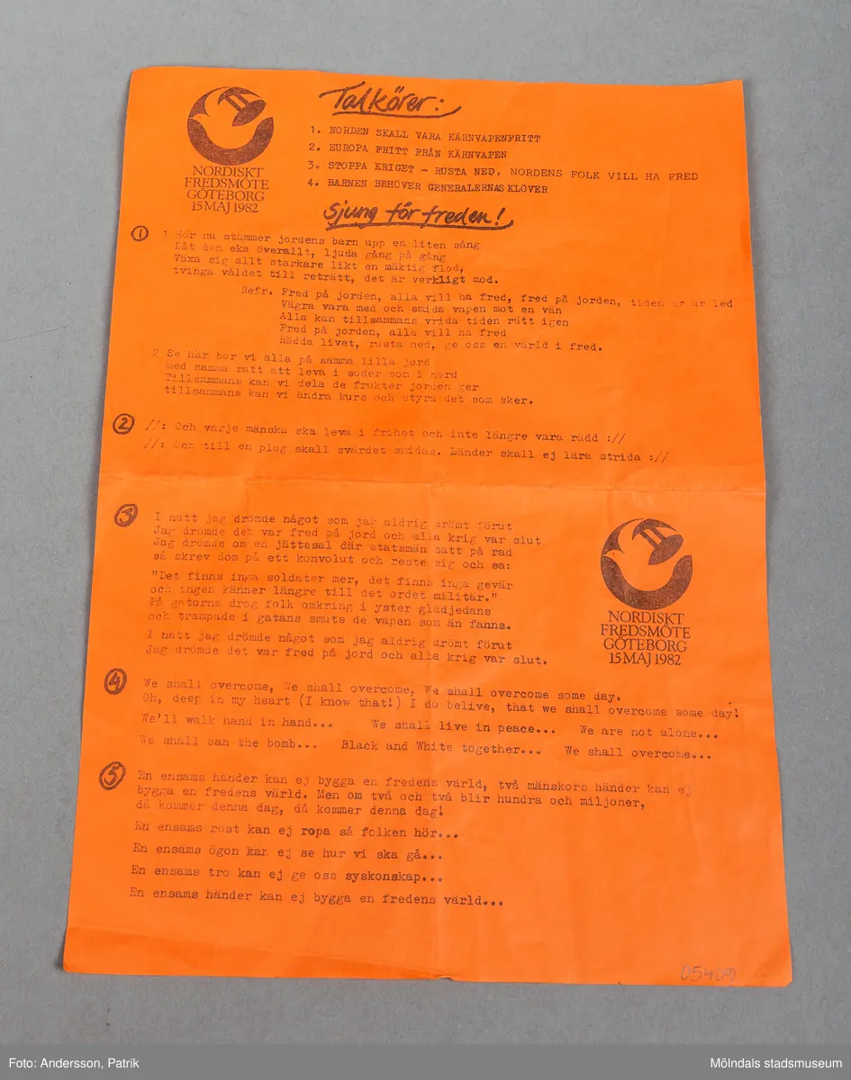 Ett orange pappersark med sångtexter. På vänster övre del finns ett emblem med en rund ring som innehåller en fredsduva.
Under ringen står det "Nordiskt fredmöte Göteborg 1982"
Arket har text endast på framsidan. 
Det finns en rubrik där det står "Sjung för freden"
Längre ned på papprets högra del, finns ett likadant emblem som uppe till vänster.
Det finns fem inringade siffror ( 1-5) med sånger.