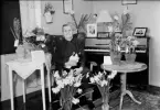 Kvinna i hemmet omgiven av blommor, Upplands-Tuna, Tuna socken, Uppland, 1952