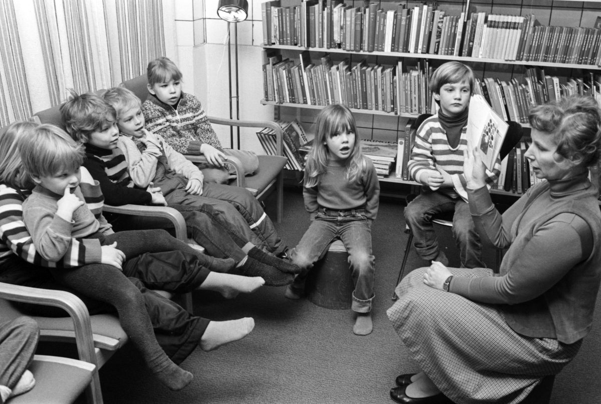 Sagostund i Stora Vika bibliotek. En kvinna läser böcker för en grupp barn. 

Kultur, litteratur, läsning, fritid.

Personer på bilden:
Siv Landin (skolbibliotekarie) längst till höger, eleven närmast henne är Robin Stegmar.