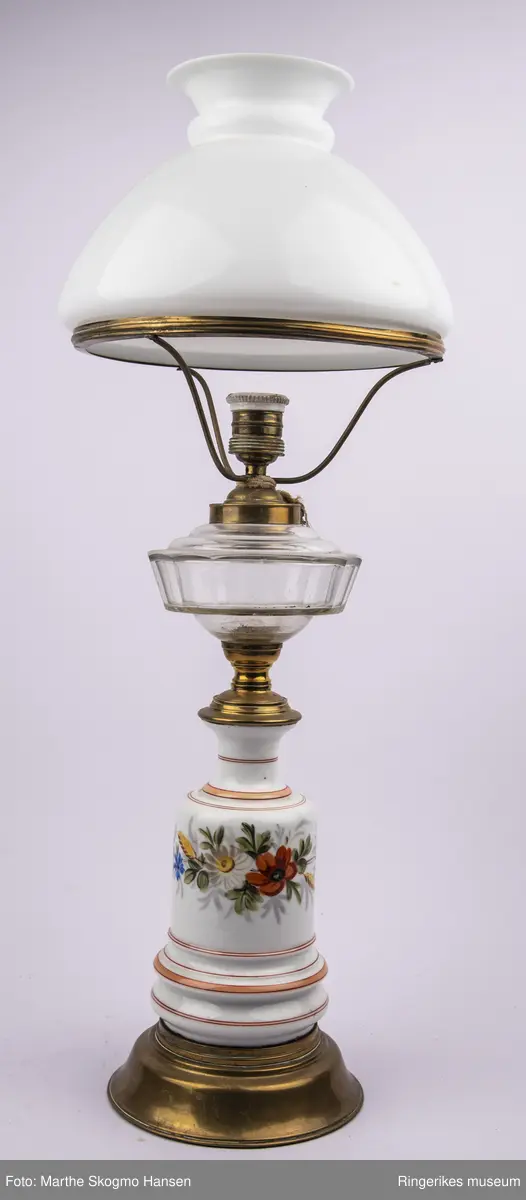 Parafinlampe gjort om til elektrisk lampe. Bordlampe i porselen med malte blomster, messing og glass.