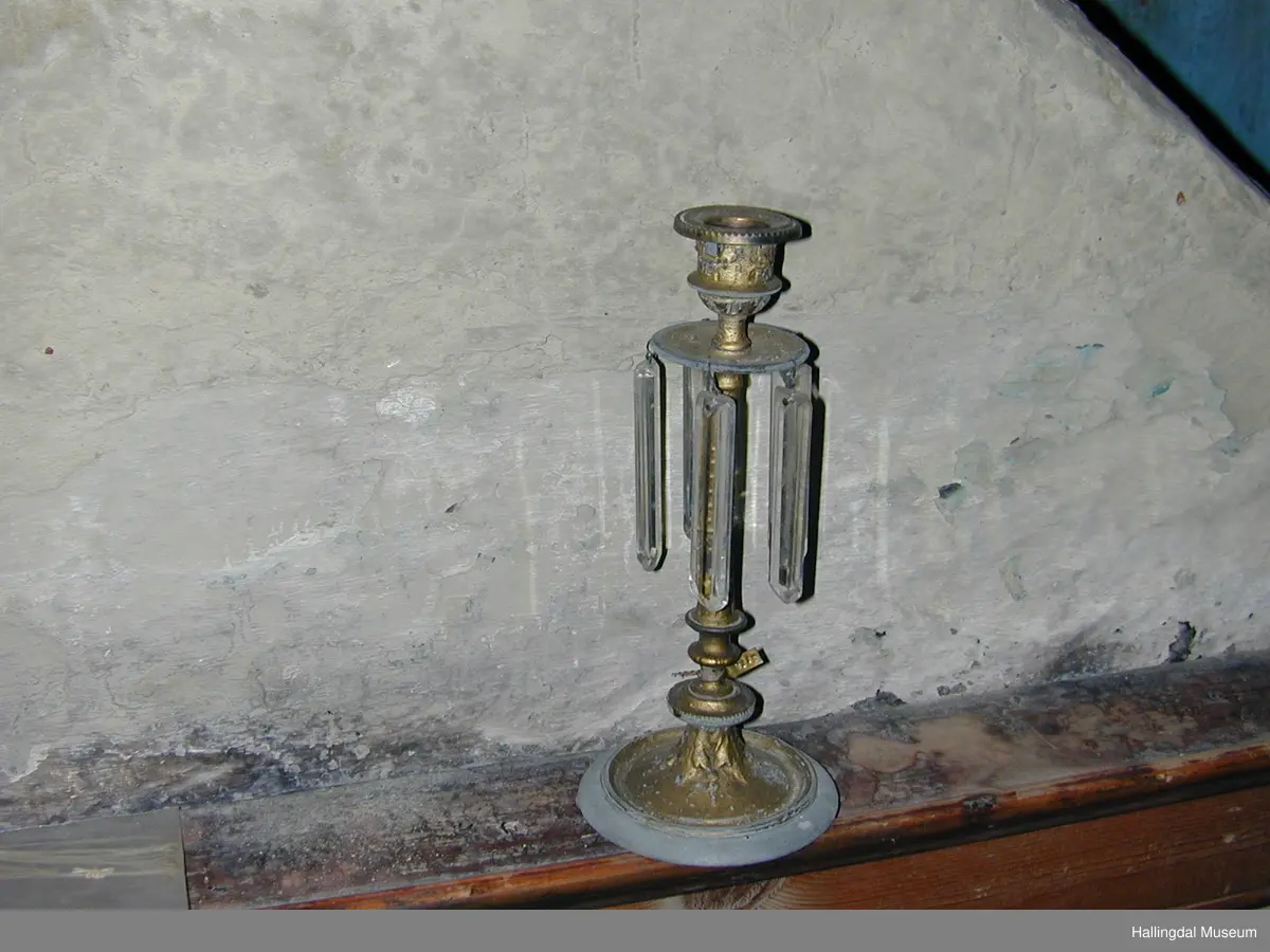 Lysestake i messing. Litt støypt ornamentikk på koppen, skåla og foten.