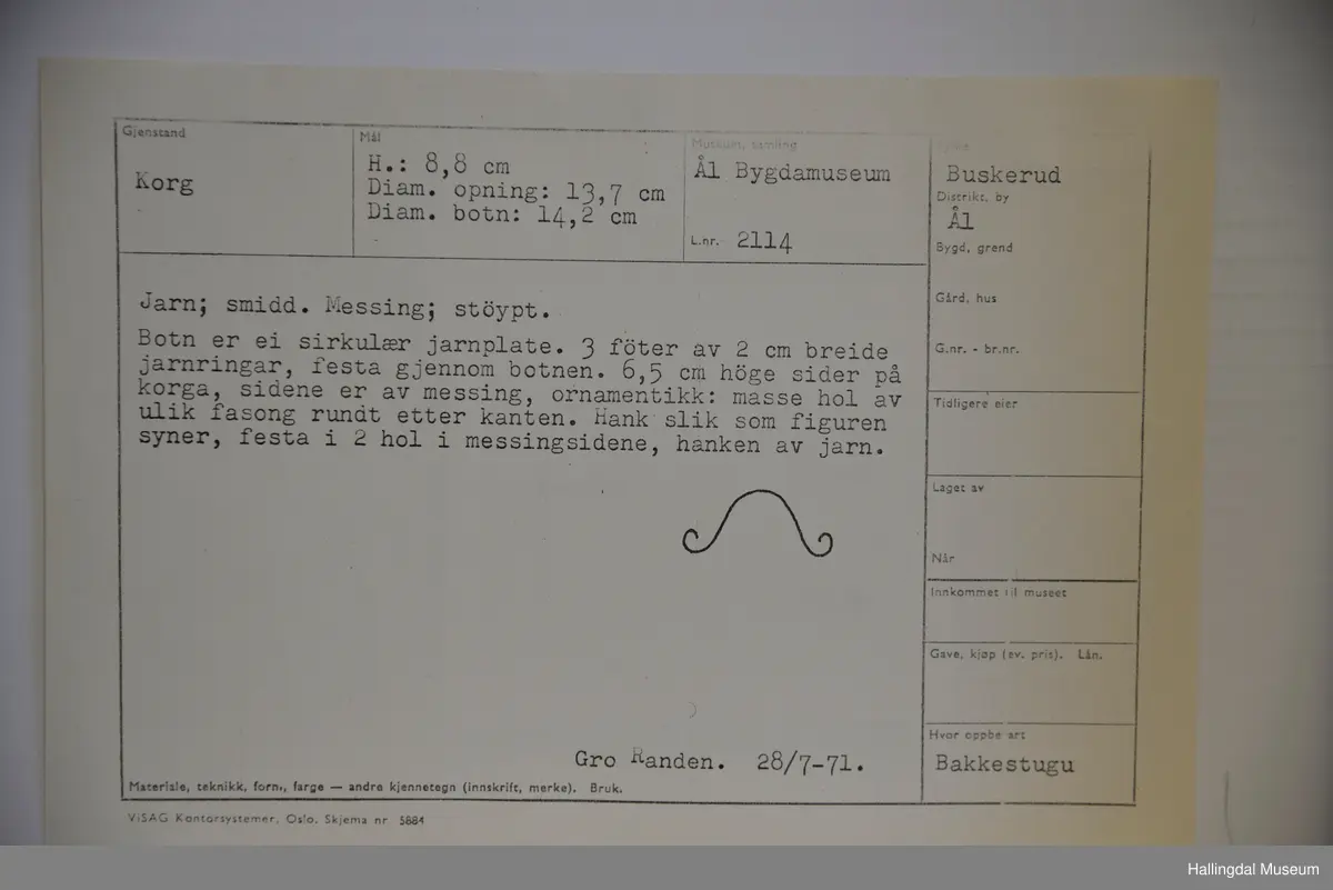 Botn er ei rund jarnplate. 3 føter, festa gjennom botnen. Sidene er av messing, ornamnetikk, masse hol av ulik fasong rundt etter kanten. Hank festa i 2 hol i messingsidene, hank av jarn.
