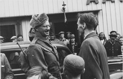 To menn hilser på hverandre foran en bil. Flere mennesker i bakgrunnen. Mannen til venstre er antatt Otto Pahle.