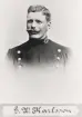 Poliskonstapel G.W. Karlsson, Växjö. 
Bröstbild, halvprofil. Ateljéfoto.