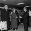 Direktör Paul Holmer ger en bukett blommor till en av kunderna vid öppning av det nya varuhuset Rosen i Huskvarna den 8 april år 1965.