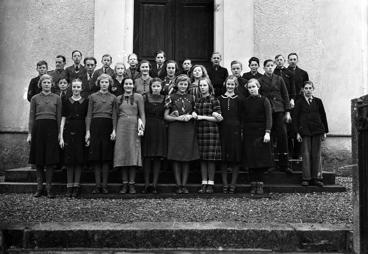 Foto av en skolklass med lärare, som samlats utanför skolan (?).