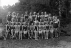 Foto av en grupp flickor i baddräkt.
Simskola (?).