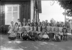 Foto av en skolklass med lärarinna, som samlats utanför skolan.