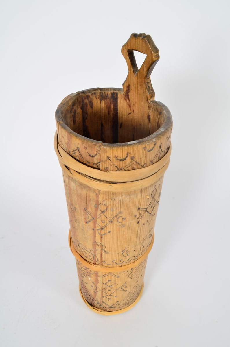 Kjerne (kinne) i furu. Lagget. En gjord nede, en på midten og to oppe, av nyere dato. Hele kjerna er dekorert med sviornamentikk med dyre- og menneskebilder.