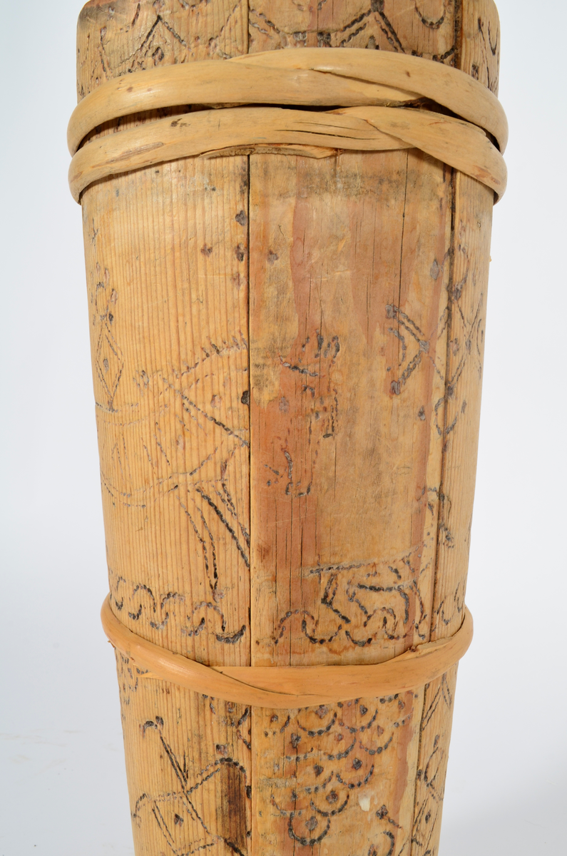 Kjerne (kinne) i furu. Lagget. En gjord nede, en på midten og to oppe, av nyere dato. Hele kjerna er dekorert med sviornamentikk med dyre- og menneskebilder.