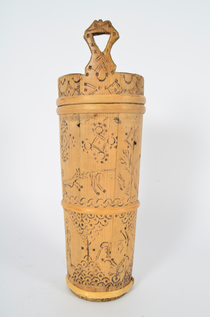 Kjerne (kinne) i furu. Lagget. En gjord nede, en på midten og to oppe, av nyere dato. Hele kjerna er dekorert med sviornamentikk med dyre- og menneskebilder.