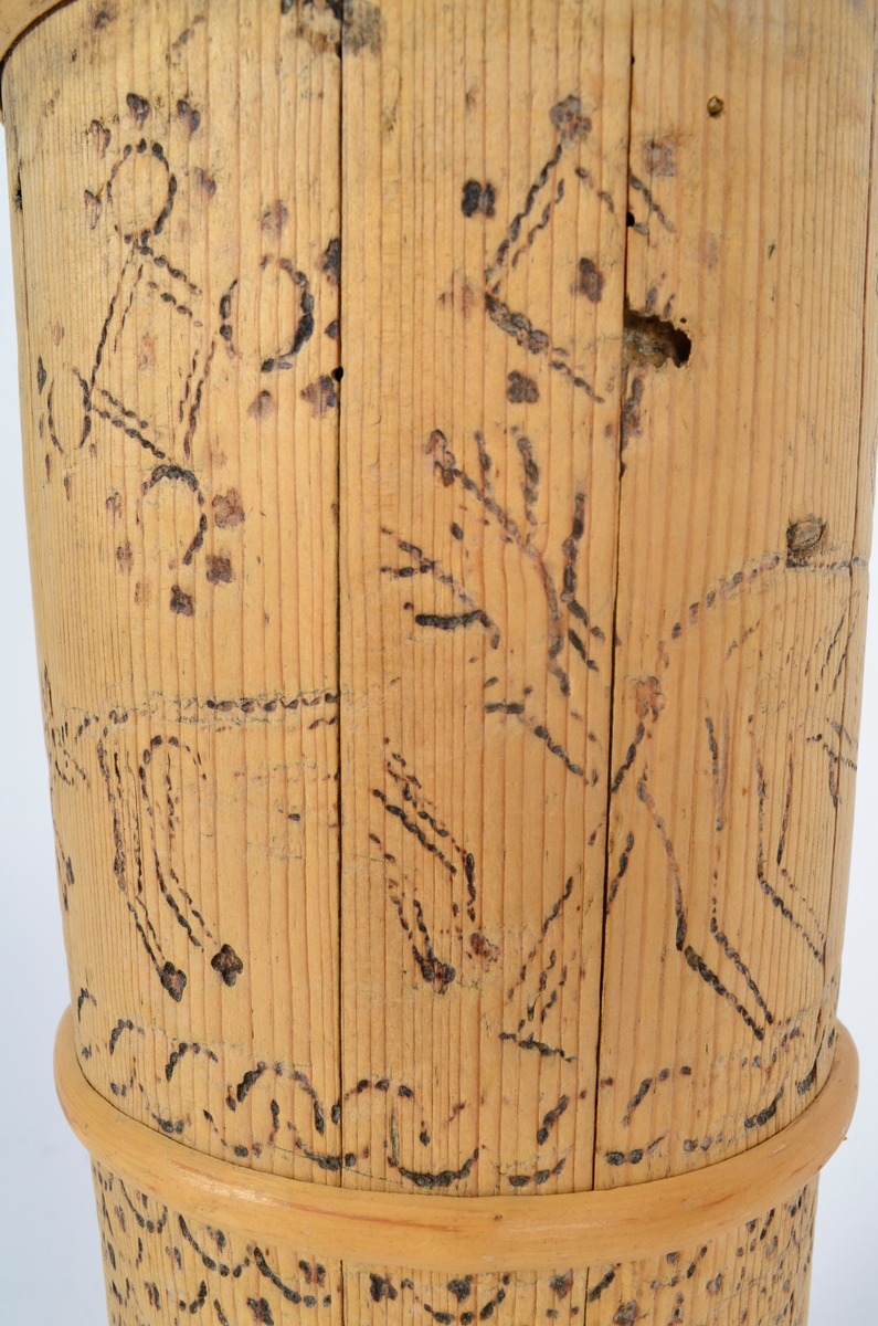 Kjerne (kinne) i furu. Lagget. En gjord nede, en på midten og to oppe, av nyere dato. Hele kjerna er dekorert med sviornamentikk med dyre- og menneskebilder.