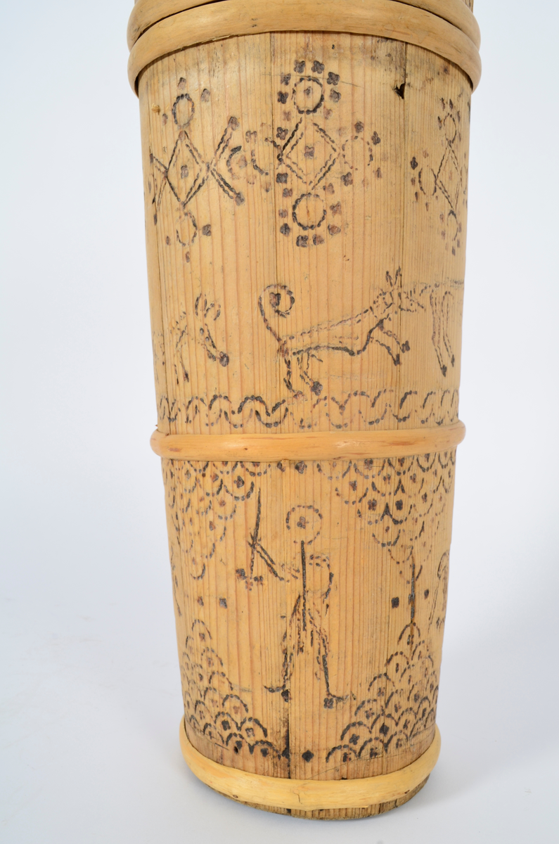 Kjerne (kinne) i furu. Lagget. En gjord nede, en på midten og to oppe, av nyere dato. Hele kjerna er dekorert med sviornamentikk med dyre- og menneskebilder.