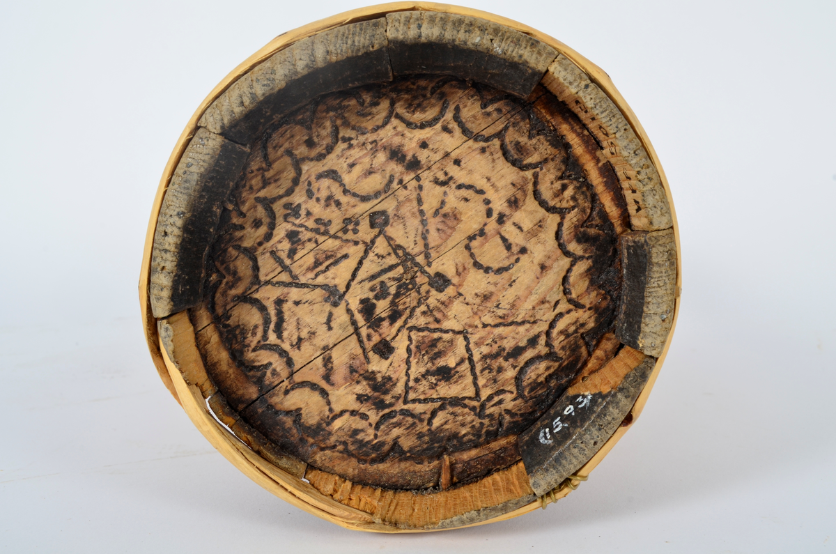 Kjerne (kinne) i furu. Lagget. En gjord nede, en på midten og to oppe, av nyere dato. Hele kjerna er dekorert med sviornamentikk med dyre- og menneskebilder.