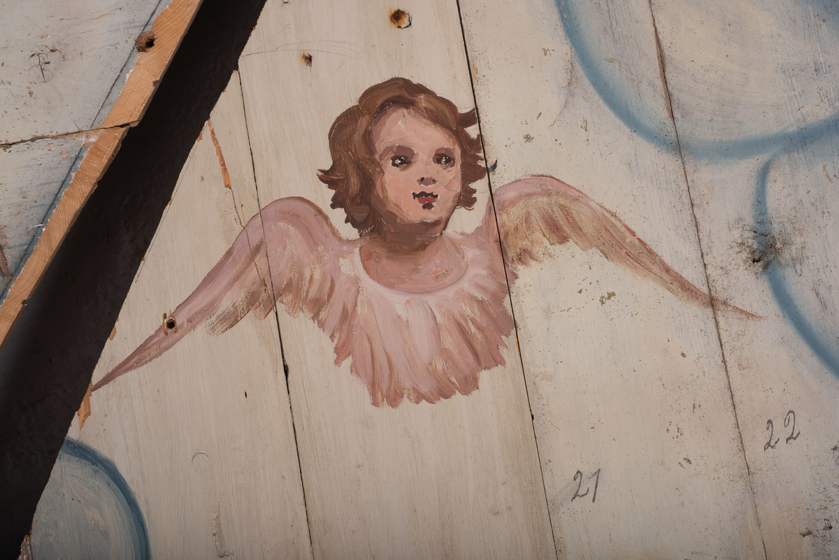 Himling i treverkt med  dekormalerier i rokokkostil av engler og skyer. Det midterste feltet er blått. De firefeltene rundt settes sammen litt på skrått slik at får en konkav konstruksjon.