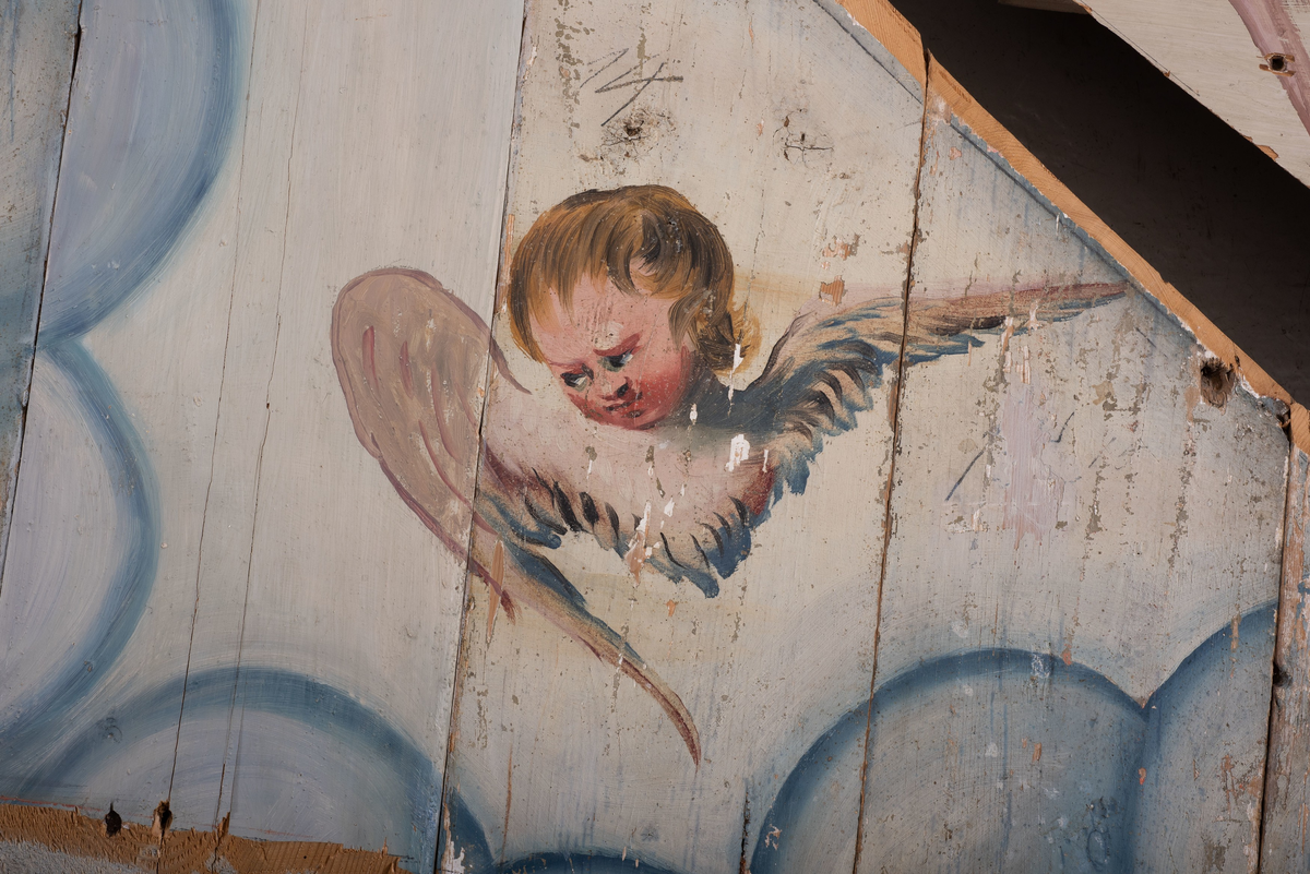 Himling i treverkt med  dekormalerier i rokokkostil av engler og skyer. Det midterste feltet er blått. De firefeltene rundt settes sammen litt på skrått slik at får en konkav konstruksjon.