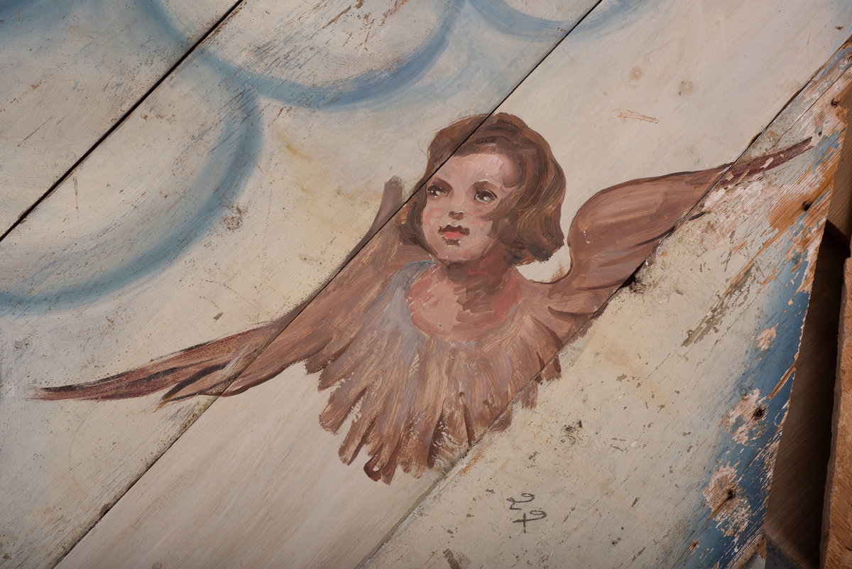 Himling i treverkt med  dekormalerier i rokokkostil av engler og skyer. Det midterste feltet er blått. De firefeltene rundt settes sammen litt på skrått slik at får en konkav konstruksjon.