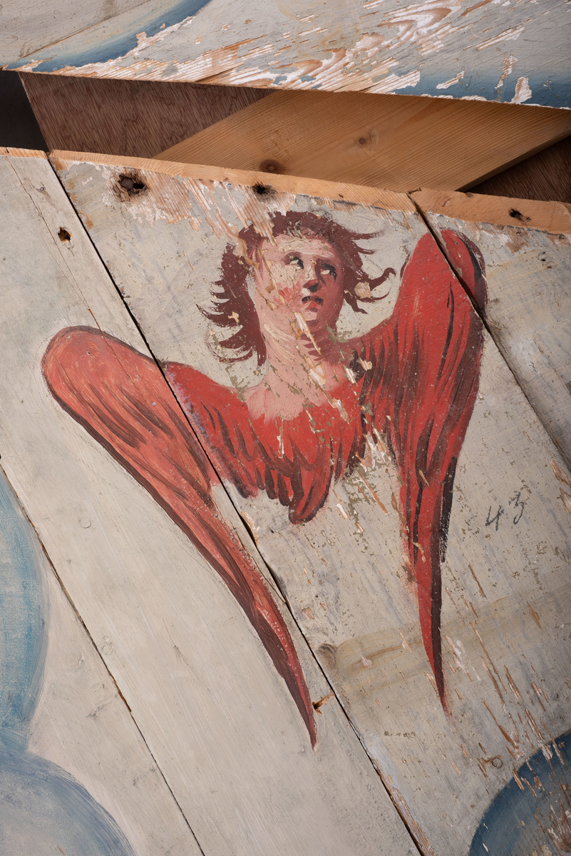 Himling i treverkt med  dekormalerier i rokokkostil av engler og skyer. Det midterste feltet er blått. De firefeltene rundt settes sammen litt på skrått slik at får en konkav konstruksjon.