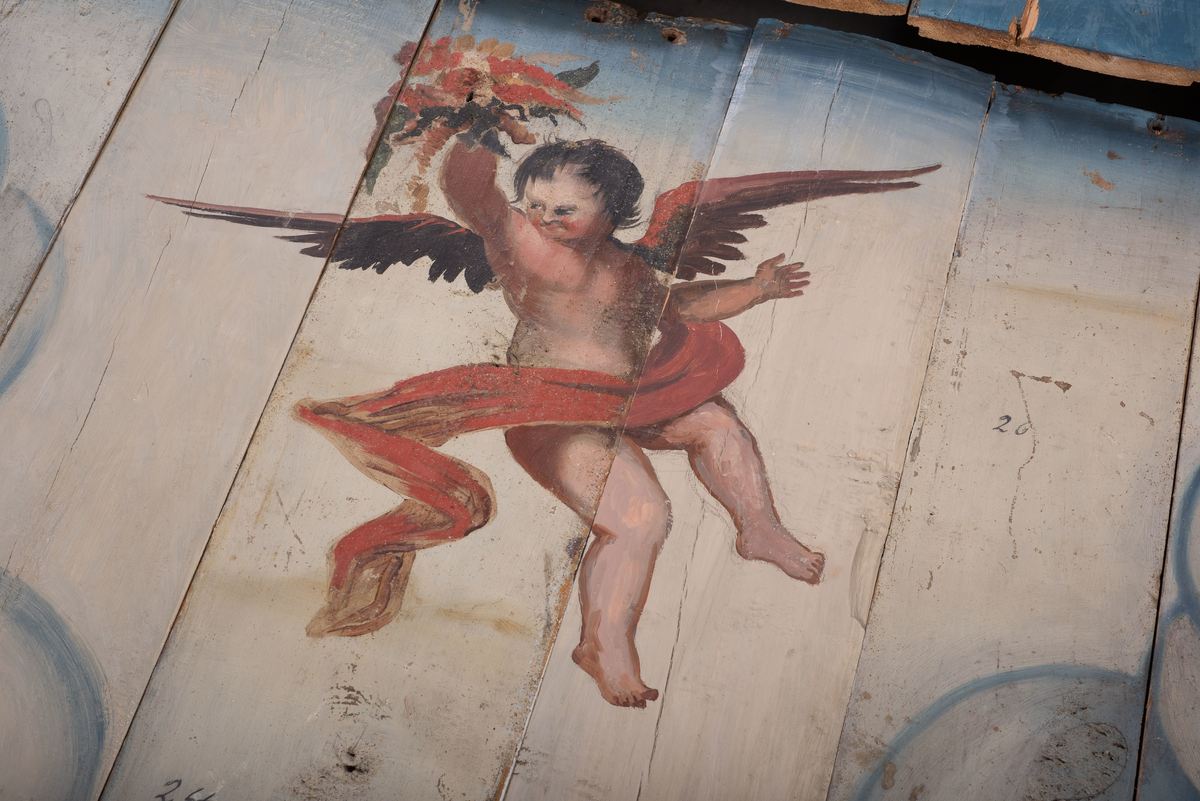 Himling i treverkt med  dekormalerier i rokokkostil av engler og skyer. Det midterste feltet er blått. De firefeltene rundt settes sammen litt på skrått slik at får en konkav konstruksjon.