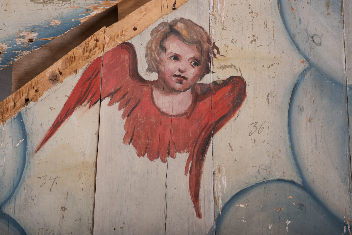 Himling i treverkt med  dekormalerier i rokokkostil av engler og skyer. Det midterste feltet er blått. De firefeltene rundt settes sammen litt på skrått slik at får en konkav konstruksjon.