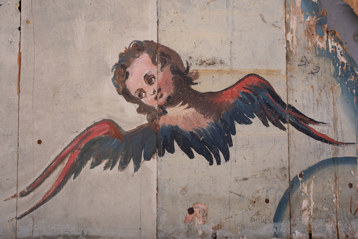 Himling i treverkt med  dekormalerier i rokokkostil av engler og skyer. Det midterste feltet er blått. De firefeltene rundt settes sammen litt på skrått slik at får en konkav konstruksjon.