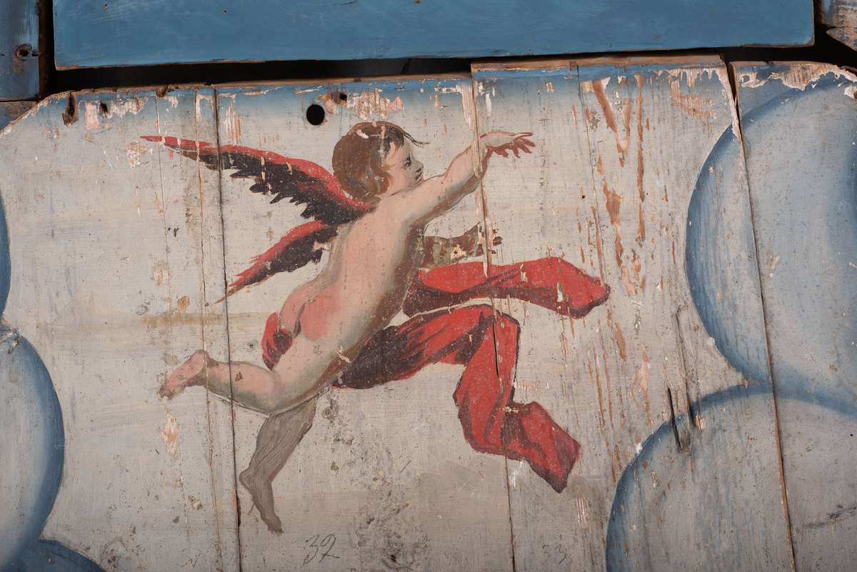 Himling i treverkt med  dekormalerier i rokokkostil av engler og skyer. Det midterste feltet er blått. De firefeltene rundt settes sammen litt på skrått slik at får en konkav konstruksjon.