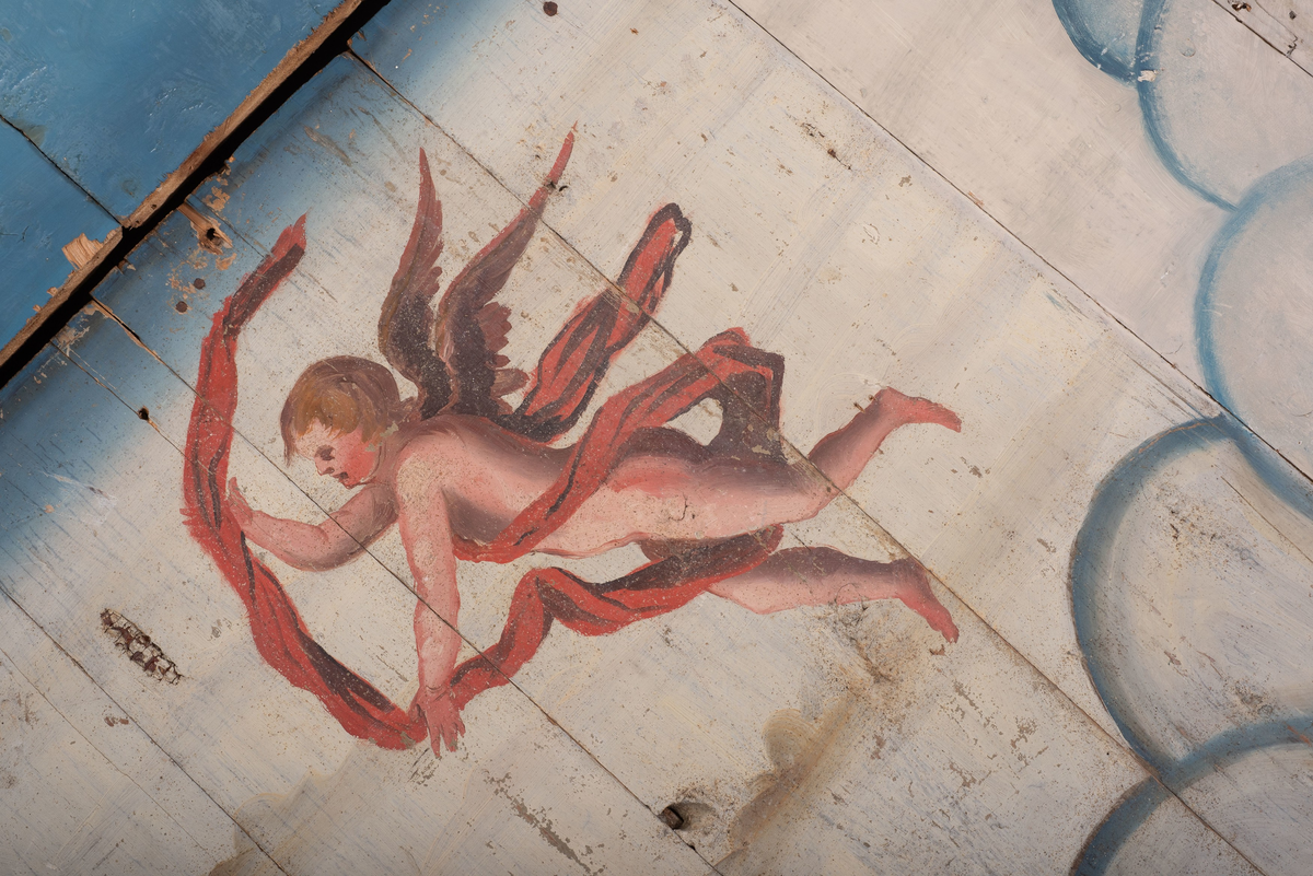 Himling i treverkt med  dekormalerier i rokokkostil av engler og skyer. Det midterste feltet er blått. De firefeltene rundt settes sammen litt på skrått slik at får en konkav konstruksjon.