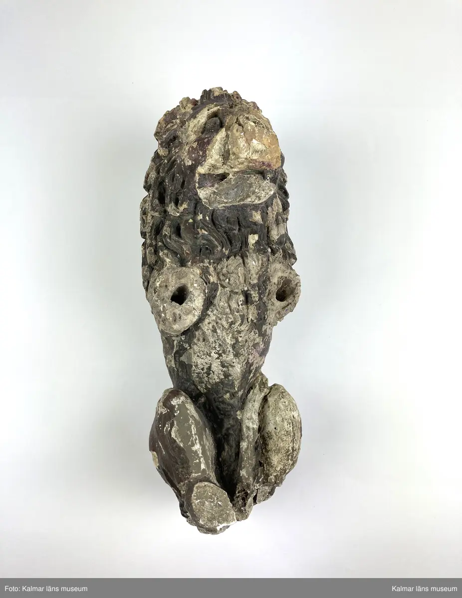 KLM 46406. Skulptur. Gjuten skulptur av gips föreställande ett stående lejon. Rester av bemålning i övervägande bruna toner. Lejonets framben samt delar av bakbenen och plattan som den stått på saknas. Två lösa delar till skulpturens nedre del finns bevarade.
