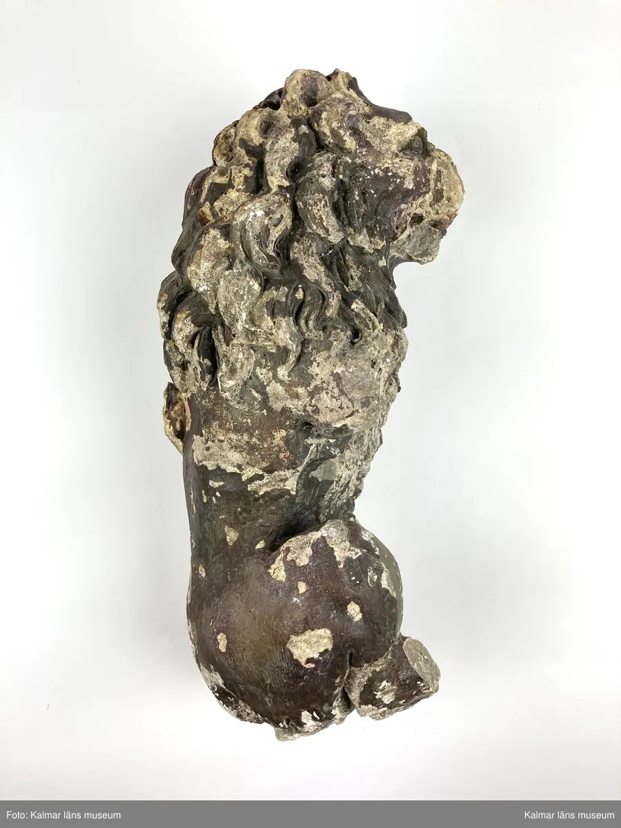 KLM 46406. Skulptur. Gjuten skulptur av gips föreställande ett stående lejon. Rester av bemålning i övervägande bruna toner. Lejonets framben samt delar av bakbenen och plattan som den stått på saknas. Två lösa delar till skulpturens nedre del finns bevarade.