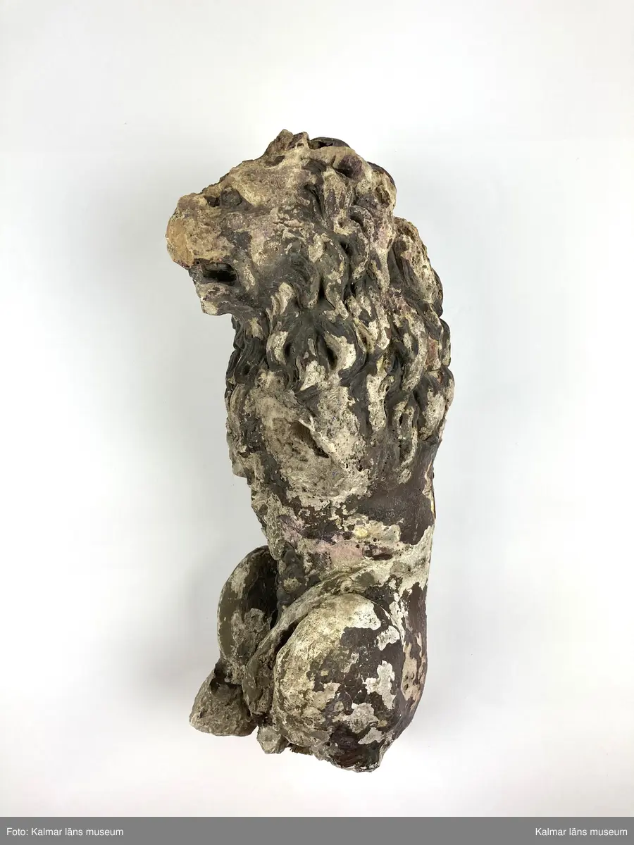 KLM 46406. Skulptur. Gjuten skulptur av gips föreställande ett stående lejon. Rester av bemålning i övervägande bruna toner. Lejonets framben samt delar av bakbenen och plattan som den stått på saknas. Två lösa delar till skulpturens nedre del finns bevarade.
