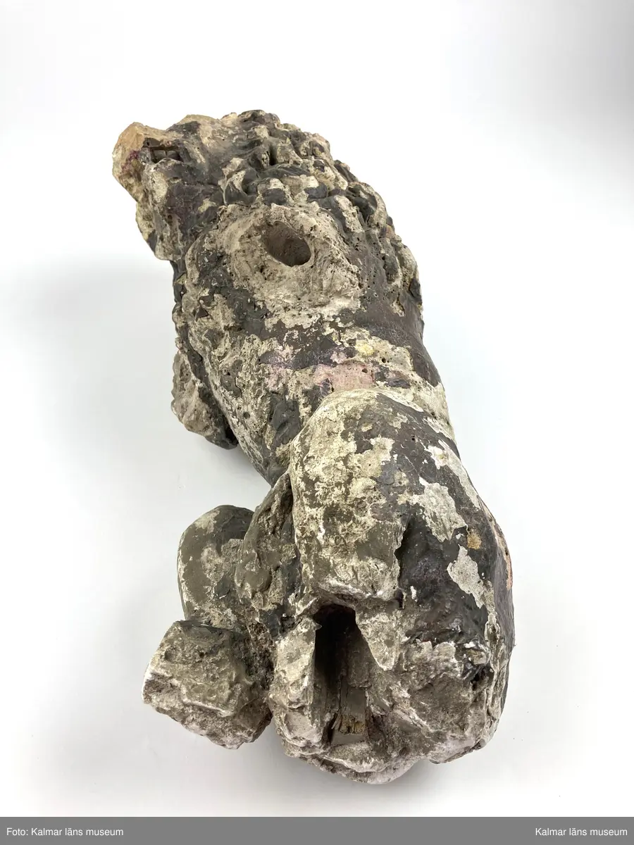 KLM 46406. Skulptur. Gjuten skulptur av gips föreställande ett stående lejon. Rester av bemålning i övervägande bruna toner. Lejonets framben samt delar av bakbenen och plattan som den stått på saknas. Två lösa delar till skulpturens nedre del finns bevarade.